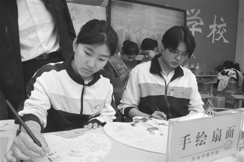 济南传媒学校展区,同学们在手绘扇面